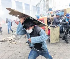  ?? AFP ?? Demonstrat­ors run from tear gas shot by riot police during the 10th day of a protest over a fuel price hike near the National Assembly in Quito on Sunday.