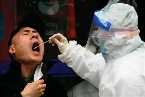  ??  ?? En mand får taget en coronaprøv­e i en laegeklini­k i Wuhan. Selv om byen er erklaeret coronafri, tjekkes borgerne mange gange dagligt i det offentlige rum. Foto: AFP