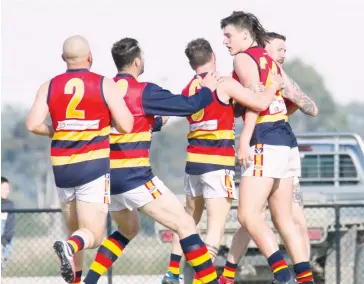  ??  ?? Longwarry’s players are quick to flock to first gamer Lachlan Spinks (right) who kicked the first goal of the match in a dream start to his senior debut.