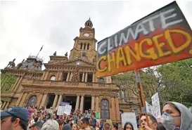  ?? (AFP) ?? People gather in front of the Town Hall during a climate protest rally in Sydney on Wednesday