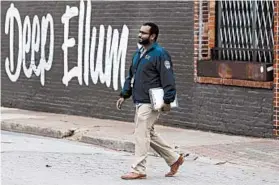  ?? LM OTERO/AP ?? Code compliance officer Eldho Babu checks on businesses amid concerns of COVID-19 spreading Tuesday in the Deep Ellum section of Dallas.