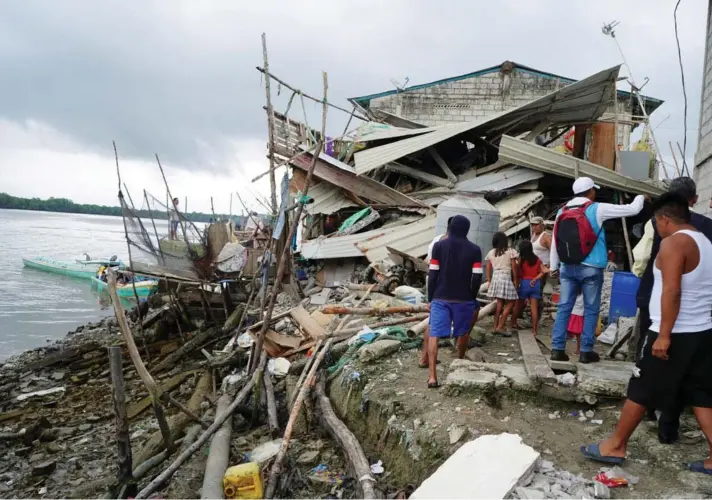  ?? ?? ► La gente mira una casa destruida tras un terremoto en Isla Puna, Ecuador, ayer domingo.