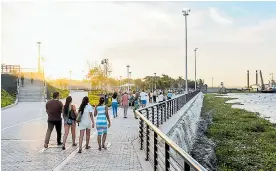  ??  ?? Familias contemplan el río Magdalena durante su visita al Gran Malecón.