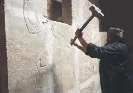  ??  ?? This image made from video posted online by Islamic State militants in April 2015 shows a militant taking a sledgehamm­er to a stone carving at the ancient site of Nimrud near Mosul, Iraq. Militant video via The Associated Press