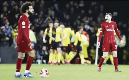  ??  ?? Liverpool’s Andrew Robertson, right, reacts as Watford players celebrate after Troy Deeney scores their third goal.