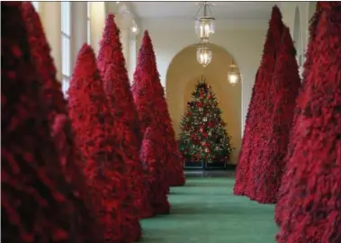  ?? CAROLYN KASTER — THE ASSOCIATED PRESS FILE ?? Topiary trees line the East colonnade during the 2018 Christmas preview at the White House in Washington. Melania Trump’s cranberry topiary trees may have left some of her critics seeing red, but they turned out to be a hit this Christmas — one of several new wrinkles the Trumps introduced this holiday season.
