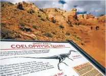  ??  ?? A sign depicting a Coelophysi­s dinosaur at the mouth of the Whitaker quarry on Oct. 10, where more than a thousand fossil skeletons were found, adjacent to Kitchen Mesa at Ghost Ranch.