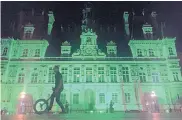  ?? NADINE ACHOUI-LESAGE/ASSOCIATED PRESS ?? City Hall in Paris, France, is illuminate­d in green following the announceme­nt by President Donald Trump that the U.S. will withdraw from the 2015 Paris accord.