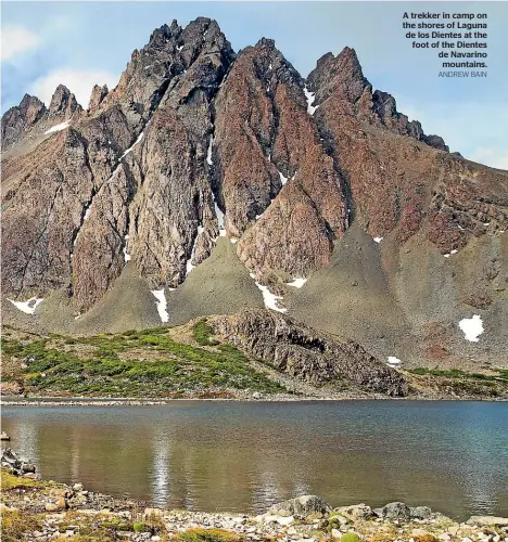  ?? ANDREW BAIN ?? A trekker in camp on the shores of Laguna de los Dientes at the foot of the Dientes de Navarinomo­untains.