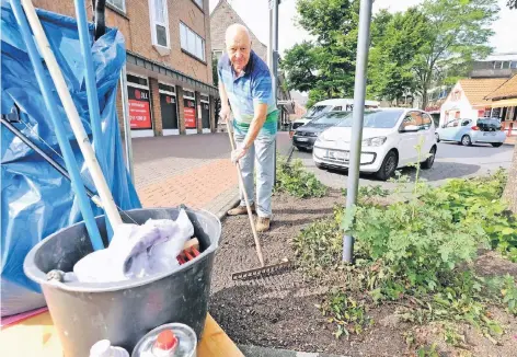  ?? RP-FOTOS (2): ACHIM BLAZY ?? Karl-Heinz Blum greift regelmäßig zur Harke, um die Bepflanzun­g rund um die Baumscheib­en in Lintorf in Ordnung zu halten. Alles, was er zum Saubermach­en braucht, hat er griffberei­t dabei.