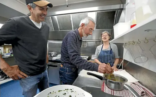  ?? MARTIN DE RUYTER/STUFF ?? David Simoni, left, and Reg Gittus are taught the finer points of making spanakopit­a by chef Sally Rees, who is running cooking classes for men at the Nelson Rugby Club.