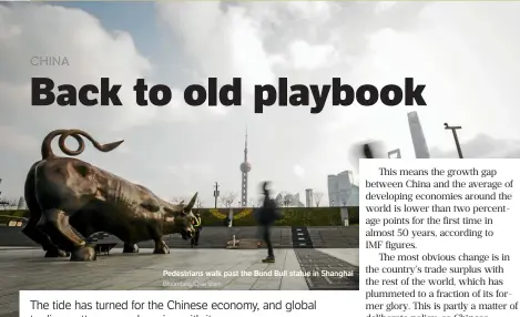  ?? Bloomberg/qilai Shen ?? Pedestrian­s walk past the Bund Bull statue in Shanghai