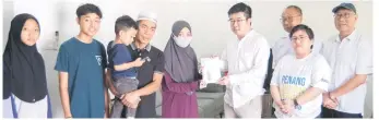  ?? — Bernama photo ?? Siti Juana (fourth left) receiving the contributi­on from Wong at Merinding Garden in Labuan on Friday.