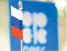  ??  ?? The Russian flag and the OPEC logo are seen before a news conference in Vienna, Austria. Russia’s vagueness on plans to trim output, and amid suspense over OPEC’s implementa­tion of an output cut in November led OCBC Bank to believe crude oil will...