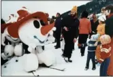  ?? (File Photo/AP) ?? A snowman mascot of the 1976 Winter Olympics in Innsbruck greets children in January 1975 in Kitzbuhel, Austria, during the world downhill ski events.