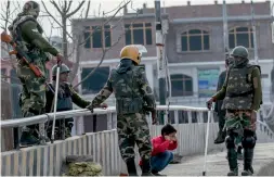  ?? — AP ?? Soldiers make a boy perform sit-ups as punishment for coming out on the street during a strike in Srinagar on Wednesday.