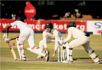  ?? — Picture by Khumbulani Mpofu ?? West Indies batsmen Kraigg Brathwaite plays a shot while Zimbabwean wicket-keeper Regis Chakabva and close fielder Craig Ervine monitor the situation on the second day of the first cricket Test at Queens Sports Club yesterday.