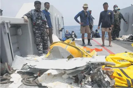  ?? Photo / AP ?? Navy divers inspect debris from the Lion Air plane during a search operation for the victims in the waters of Tanjung Karawang, Indonesia.