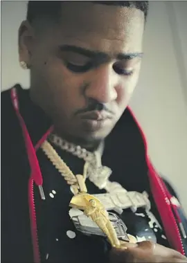  ?? Myung J. Chun Los Angeles Times ?? RALFY THE PLUG, aka Devante Caldwell, wears a medallion depicting his brother Drakeo the Ruler, who was killed in December at an L.A. music festival.