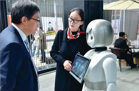  ?? LI JIANMING / FOR CHINA DAILY ?? A visitor learns about a robot during the Fifth World Internet Conference in Wuzhen, Zhejiang province.