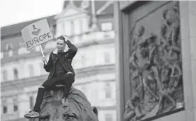  ??  ?? A demonstrat­or sits on a lion sculpture in Trafalgar Square during a Peoples Vote anti-brexit march in London. TIM IRELAND/AP