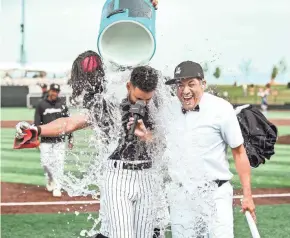  ?? MILWAUKEE MILKMEN ?? Milkmen shortstop Anibal Sierra is doused in water after having the winning hit July 11. Earlier that day, in Sierra's home country of Cuba, protests broke out in massive numbers.