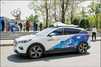  ?? ?? A Baidu Apollo Robotaxi passes its customer service counter setup at the Shougang Park in Beijing, Sunday, May 2, 2021. (AP)