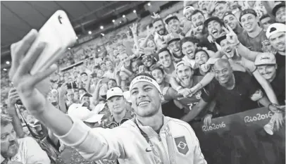  ?? ODD ANDERSEN, AFP/GETTY IMAGES ?? Brazil forward Neymar poses for a selfie with fans as they celebrate the men’s gold-medal soccer match between Brazil and Germany at the Maracana Stadium in Rio de Janeiro on Saturday. Brazil won on penalty kicks.