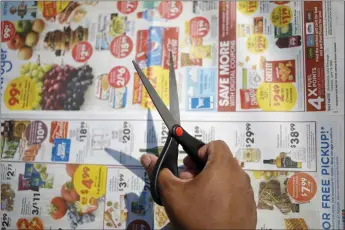  ?? PHOTOS BY LUKE SHARRETT — THE NEW YORK TIMES ?? Greg Parks, a coupon expert and blogger, looks for coupons to cut in Louisville, Ky., on June 13. As prices skyrocket, coupons are harder to find than ever.