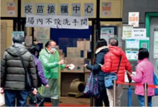  ?? ?? Residents line up to receive their COVID-19 vaccine shots in Hong Kong on February 22