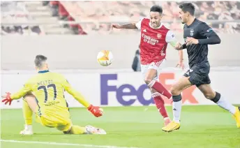 ?? — AFP photo ?? Arsenal’s Pierre-Emerick Aubameyang (centre) shoots and scores a goal during the UEFA Europa League round of 32 second leg match against Benfica at the Karaiskaki Stadium in Athens.