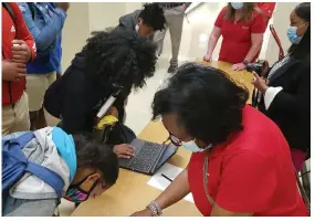  ?? (Special to The Commercial) ?? Watson Chapel Junior High School students sign a nonviolenc­e pledge recently as members of the Chairman’s Club — Red Coats look on.