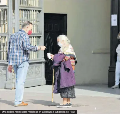  ?? ÁNGEL DE CASTRO ?? Una señora recibe unas monedas en la entrada a la basílica del Pilar.