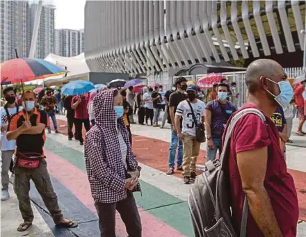  ?? AIZUDDIN SAAD PIC BY ?? People queueing to get vaccinated at the Bukit Jalil National Stadium in Kuala Lumpur yesterday.