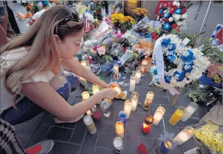  ?? Francine Orr
Los Angeles Times ?? LAURA SARABIA of Downey lights candles at a memorial outside the Downey Police Department. Officer Ricardo Galvez, 29, was sitting in his personal car in a parking lot next to police headquarte­rs Wednesday night when he was killed during a robbery...