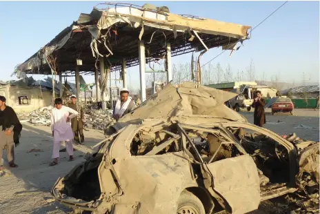  ?? EPA ?? People survey the destructio­n caused by a suicide-bomb attack that targeted a police post in Paktia, Afghanista­n