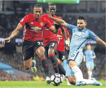  ?? Picture: Getty Images. ?? United’s Antonio Valencia does enough to prevent City striker Sergio Aguero getting on the end of a cross.