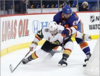  ?? KATHY WILLENS — THE ASSOCIATED PRESS ?? Vegas Golden Knights defenseman Brad Hunt (77) holds back New York Islanders center Brock Nelson (29) from the puck behind the net during the second period of a game Monday night.