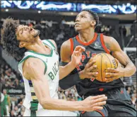  ?? Jeffrey Phelps The Associated Press ?? Raptors guard R.J. Barrett eyes the basket against Bucks guard Andre Jackson Jr. in Toronto’s victory Friday at Fiserv Forum.