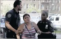  ??  ?? A woman is escorted by officers after a shooting at the Bronx Lebanon Hospital Centre in New York.