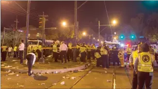  ?? The Associated Press ?? New Orleans police work at the scene where a vehicle plowed into a crowd watching the Krewe of Endymion parade on Saturday.