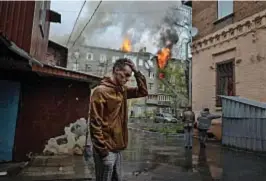  ?? ?? Nella foto del premio Pulitzer Tyler Hicks, lo choc di un uomo con alle spalle
un caseggiato di Kharkiv colpito da un missile: è il 17 aprile scorso