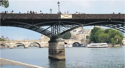  ?? Pictures / AP ?? The Pont des Arts bridge was repaired with a wooden section after the chunk of fencing fell off.