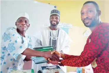  ??  ?? Principal of Junior Secondary School (JSS), Gwagwalada, Waziri D. Ali, left, presents exercise books to a representa­tive of the principal of Junior Secondary School, Kwali, Benjamin Adeseko, while a chieftain of the APC, Alhaji Ahmad Abubakar Sadiq,...