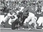  ?? AP ?? Philadelph­ia Eagles quarterbac­k Jalen Hurts, top center, is almost sacked as Jack Driscoll (63) can’t hold his block during the second half against the New York Jets on Sunday.