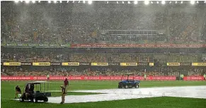  ?? ?? The wicket block is protected from the heavy rain that struck Brisbane soon after England were bowled out, forcing an early end to the day.