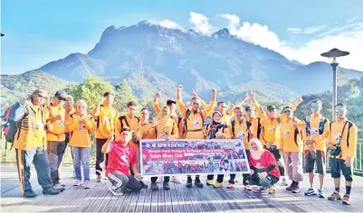  ??  ?? PENDAKI SHC bergambar berlatar belakangka­n Gunung Kinabalu.