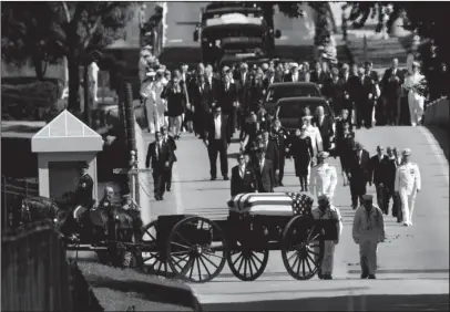  ?? The Associated Press ?? UNITED STATES NAVAL ACADEMY: Family members, including Cindy McCain, back center, follow a horse-drawn caisson that carries the casket of Sen. John McCain, R-Ariz., on Sunday as it proceeds to the United States Naval Academy cemetery in Annapolis, Md., for burial. McCain died Aug. 25 from brain cancer at age 81.