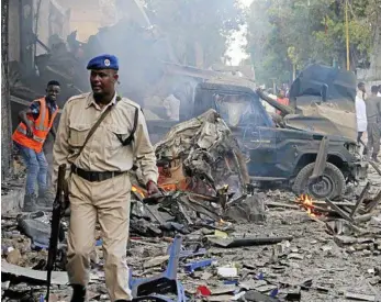  ?? PHOTO: FARAH ABDI WARSAMEH/AP ?? DEVASTATIO­N: A Somali soldier surveys the wreckage following the detonation of a car bomb and storming of a hotel by jihadists in Mogadishu.