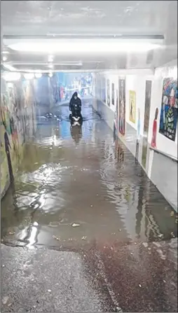  ?? Picture: Angus Macleod ?? A man on a mobility scooter risks the flooding in one of Canterbury’s underpasse­s